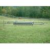 Spring regulates tension for electric fencing wires